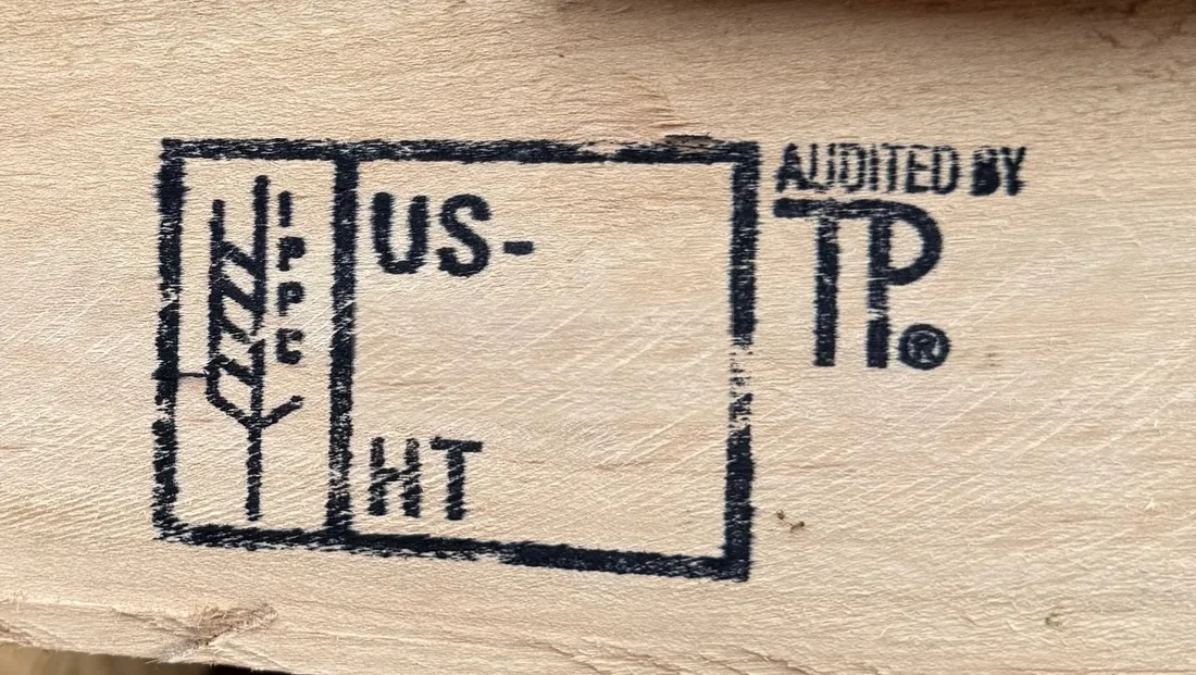 Close-up of heat-treated pallet stringers carrying our IPPC mark with the HT treatment code and the audited-by-TP mark